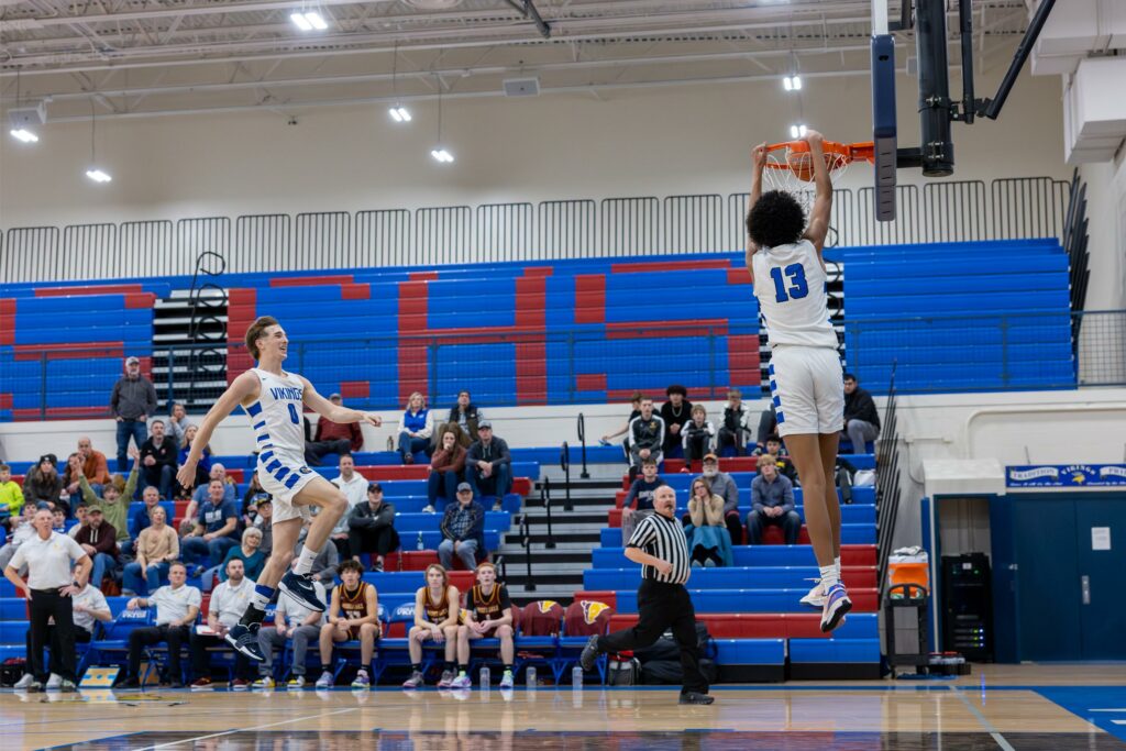 Coeur d'Alene's Maxwell Riley dunks the ball as Gunner Larson trails during Saturday's game against Moses Lake at Viking Court.
